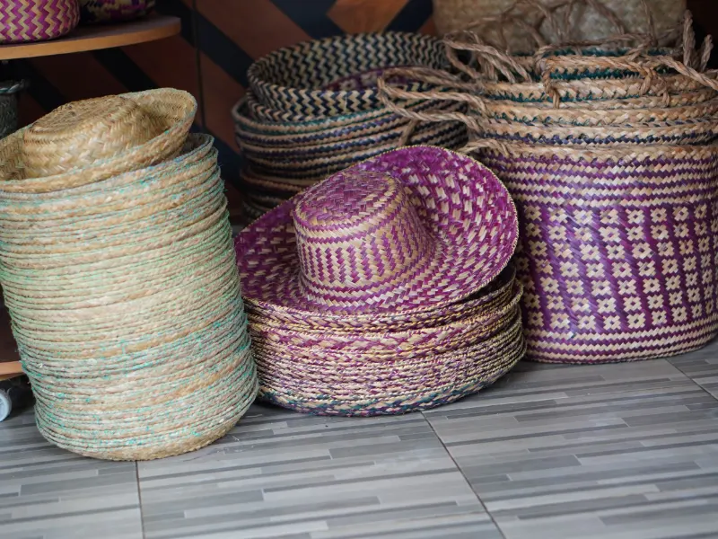 Stacks of finished purun hats and plum patterned baskets ready to pack